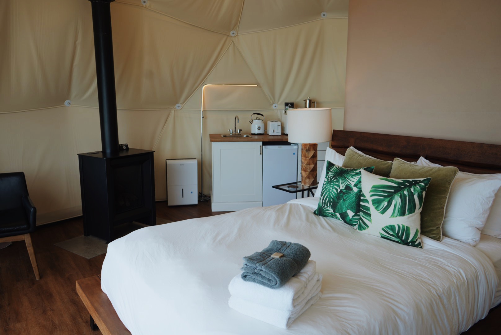 Wildpods interior with a wood stove and kitchenette